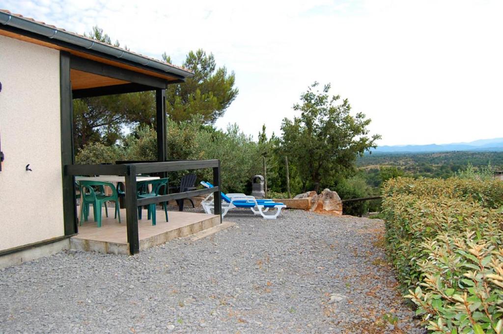 - un pavillon avec une table et des chaises sur la terrasse dans l'établissement Gîte Romarin 1 - Village De Gîtes, à Rosières