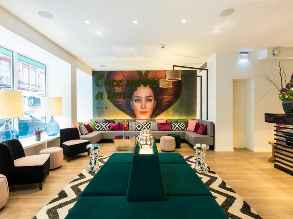 uma sala de estar com uma mesa verde e um sofá em Ibis Styles Frankfurt City em Frankfurt am Main