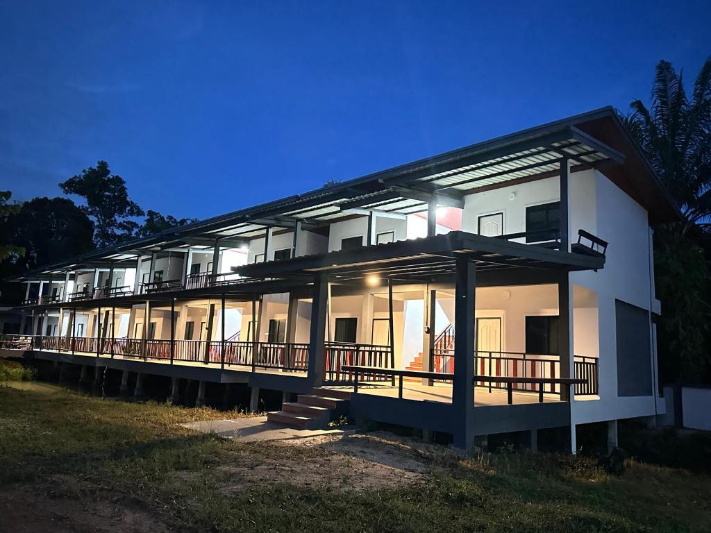 a large white building with a lot of windows at บ้านร่มไทร Ban Romsai Nadoem Suratthani in Ban Don Yung