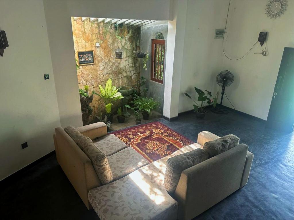a living room with a couch and an aquarium at Noah's House in Weligama