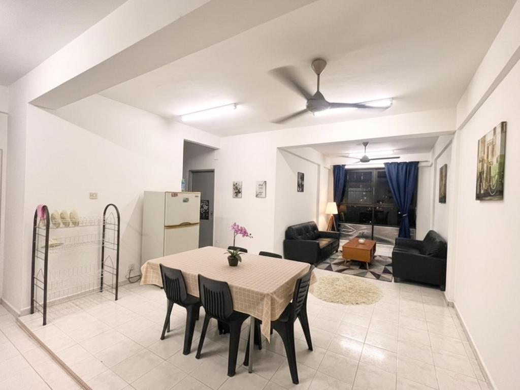a dining room and living room with a table and chairs at Cozy Stay ANJANA SERI GUEST HOUSE HOMESTAY Melaka in Ayer Keroh