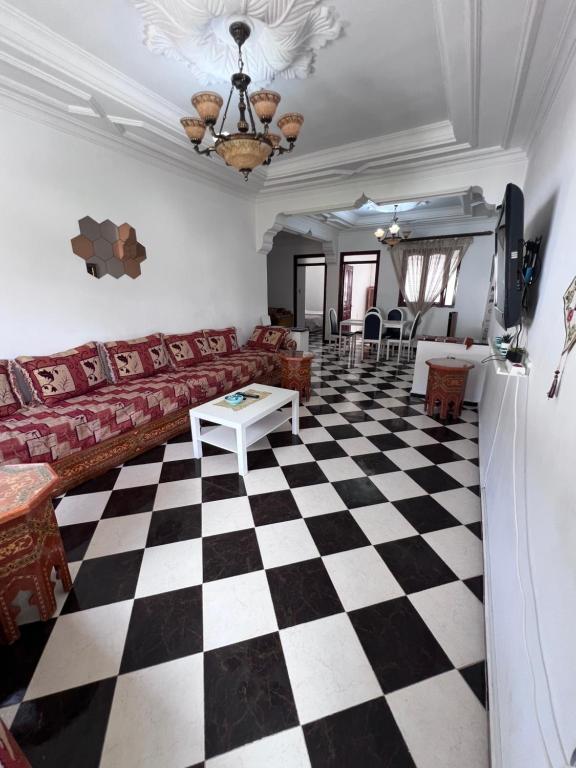 a living room with a couch and a checkerboard floor at Blue Pearl city in Chefchaouene