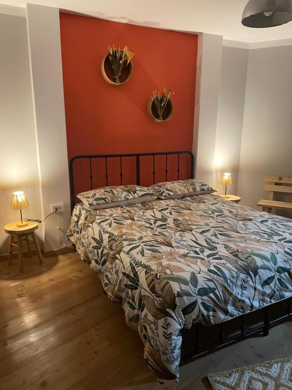 a bedroom with a bed with a red wall at Ca' Dei Sassi in Segusino