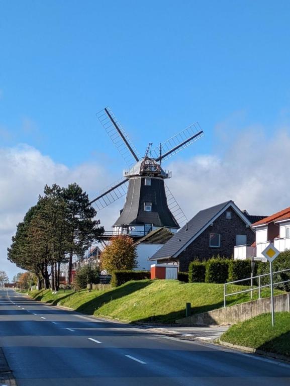 a windmill in front of a house and a street at Ankerplatz35 in Wittmund
