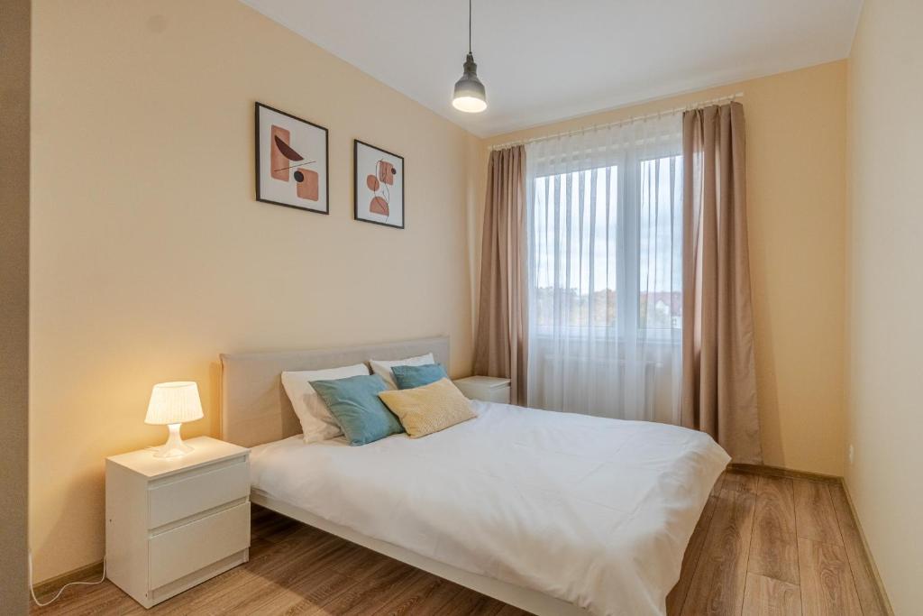 a bedroom with a white bed and a window at Apartament Odrzańskie Tarasy, Klimatyzacja, PW INVEST HOME in Krapkowice