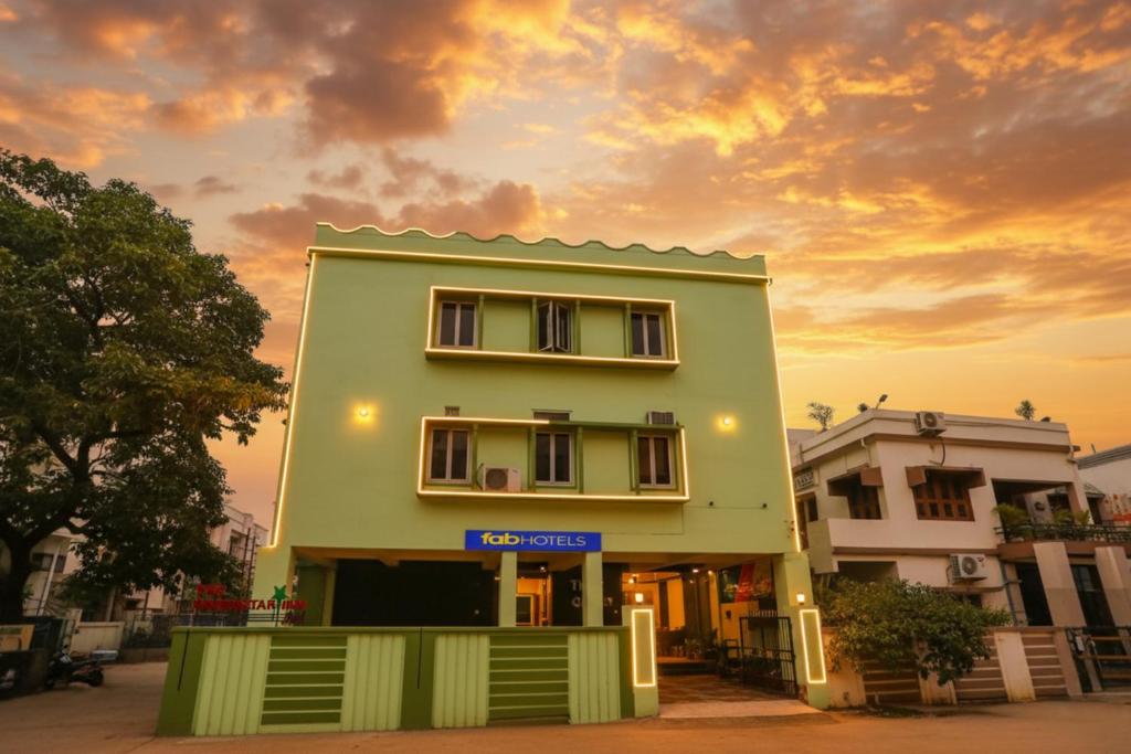 a green building with a blue sign in front of it at Via Greenstar Inn - Bhubaneswar Airport in Bhubaneshwar