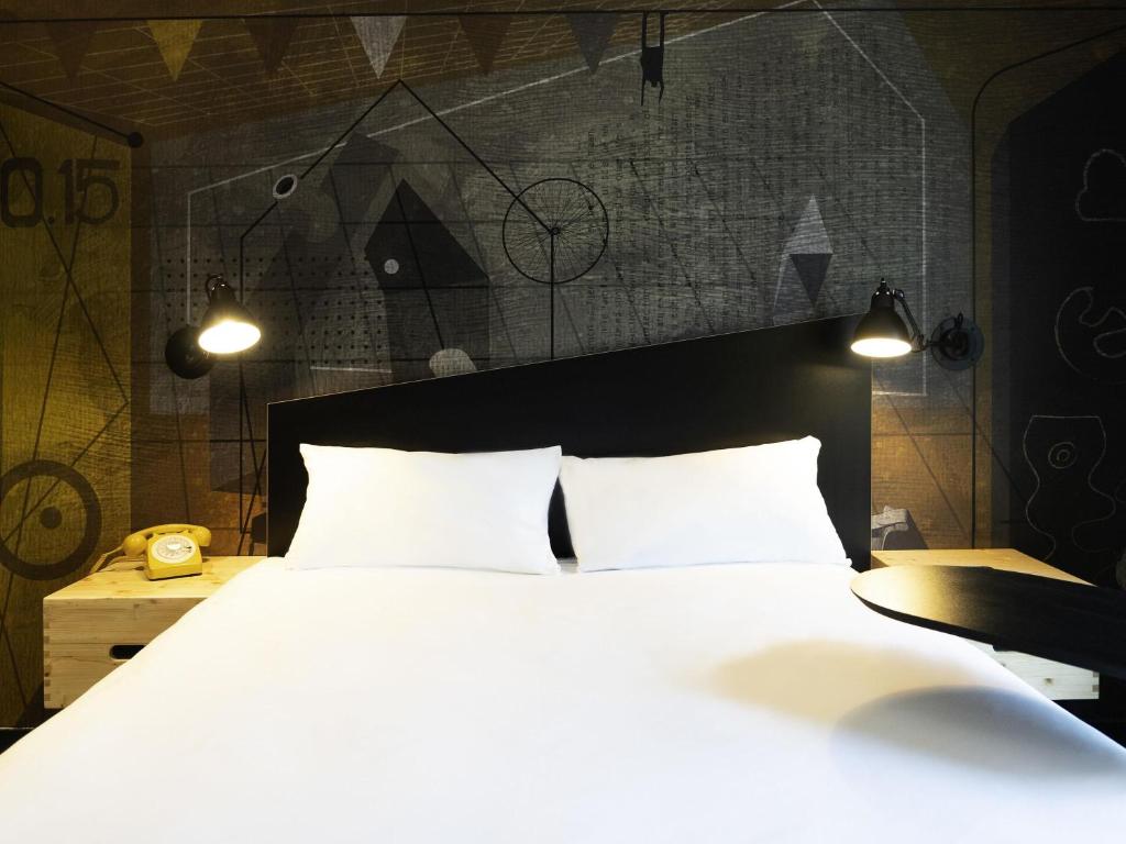 a bedroom with a large white bed with two pillows at ibis Styles Dreux Centre Gare in Dreux