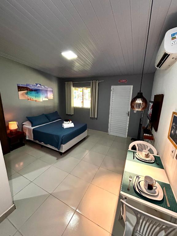 a bedroom with a bed and a table in it at Paraíso do Boldró Flat in Fernando de Noronha