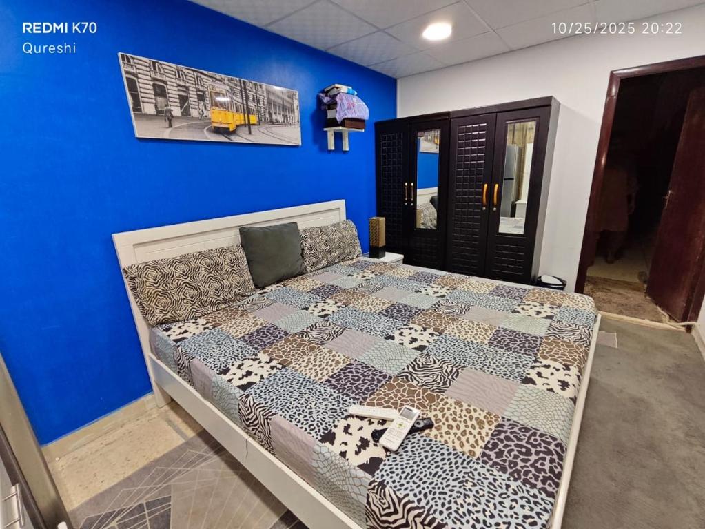 a bed in a room with a blue wall at Fully furnished bedroom c-136 in Abu Dhabi
