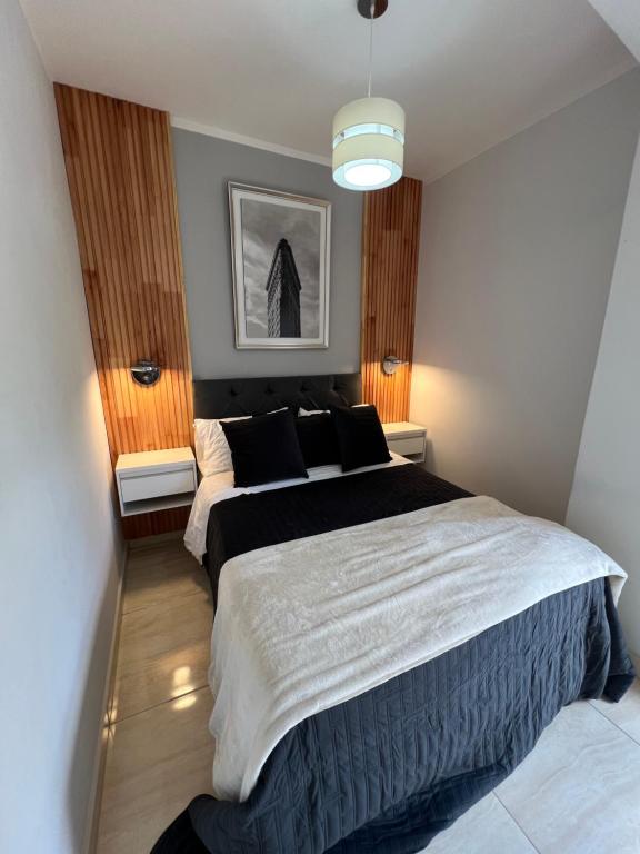 a bedroom with two beds and a pendant light at Departamento amoblado centro capital in San Juan