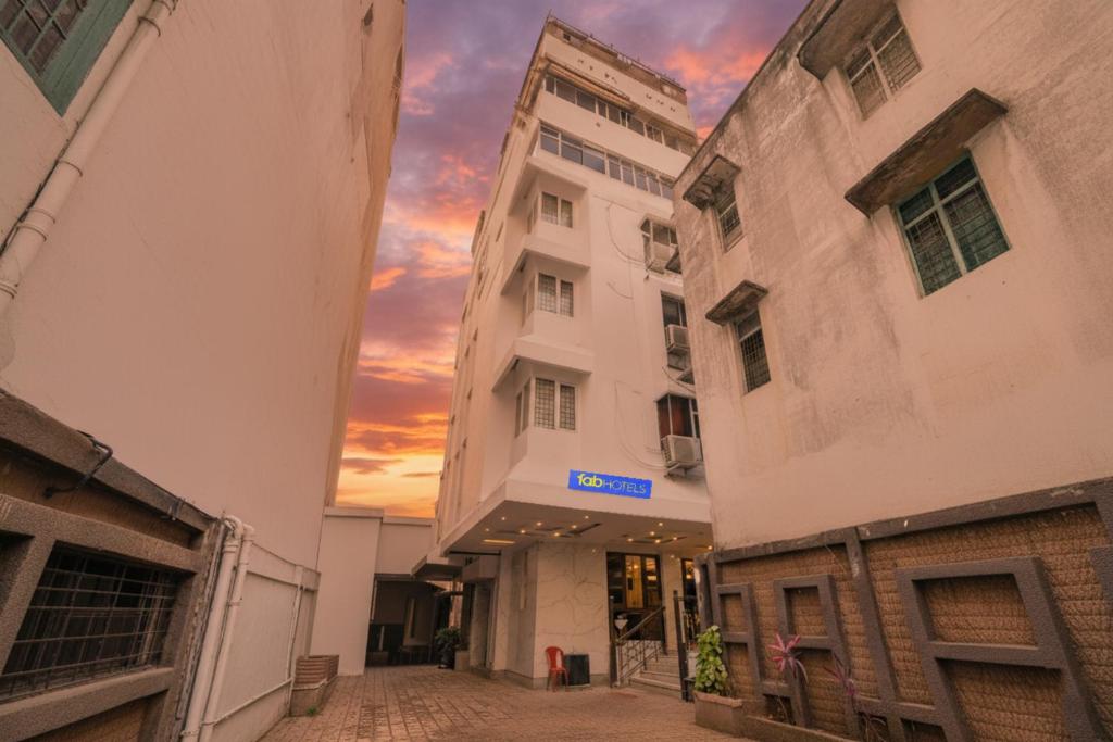 een steegje tussen twee gebouwen met een zonsondergang op de achtergrond bij FabHotel Royale Basant Residency - Gandhinagar in Bangalore