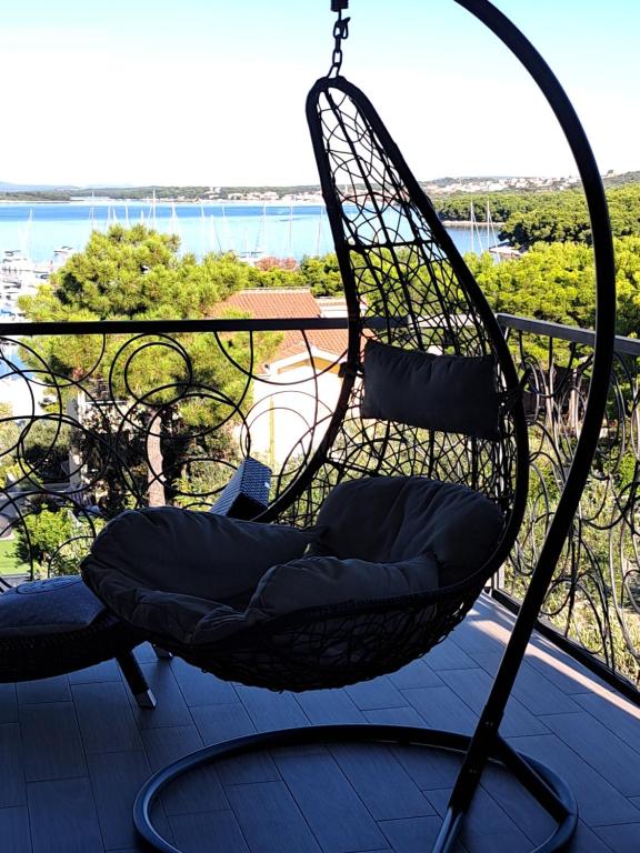 a hanging chair on a balcony with a view at Oleandra Apartments in Drage