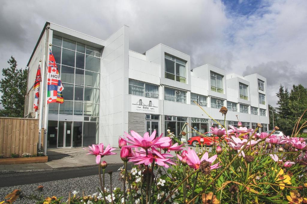 Un edificio blanco con flores delante. en Bella Apartments &amp; Rooms, en Selfoss