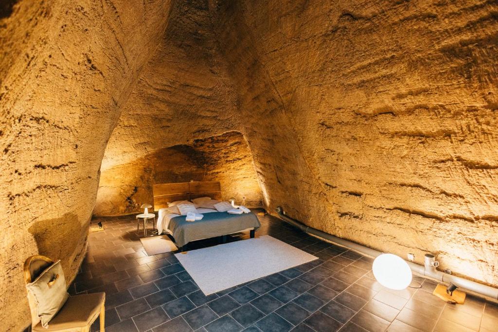 a room in a cave with a bed in it at La Galerie des voûtes oubliées in Doué-la-Fontaine
