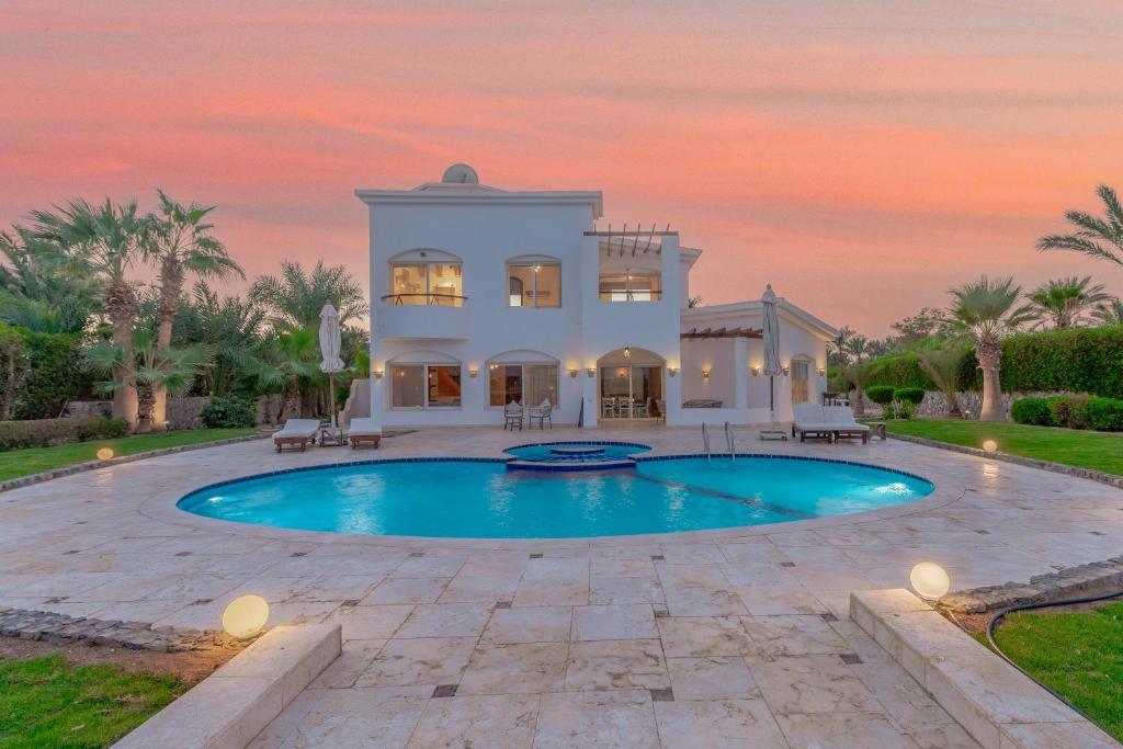 eine Villa mit einem Pool bei Sonnenuntergang in der Unterkunft Beautiful 4 BDR Villa With Private Pool in Hurghada