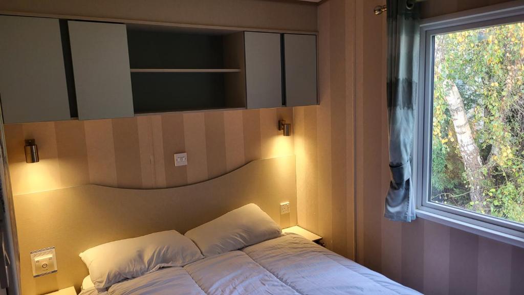 a bedroom with a bed with a window and a tv at East Lothian Escape in Port Seton