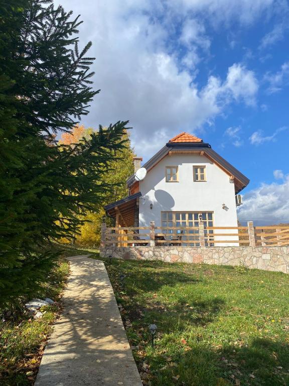 a white house with a fence and a tree at Wild peace Vladimir in Foča