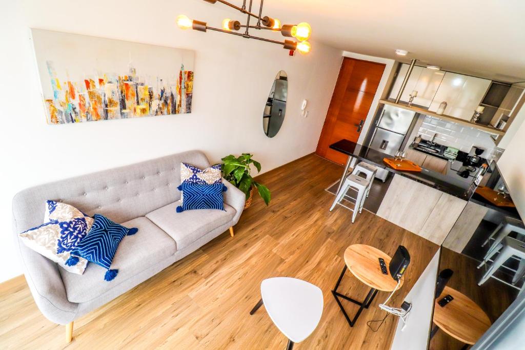 a living room with a couch and a kitchen at Vive y trabaja con estilo en San Miguel, moderno departamento de 2 dorms con balcon in Lima