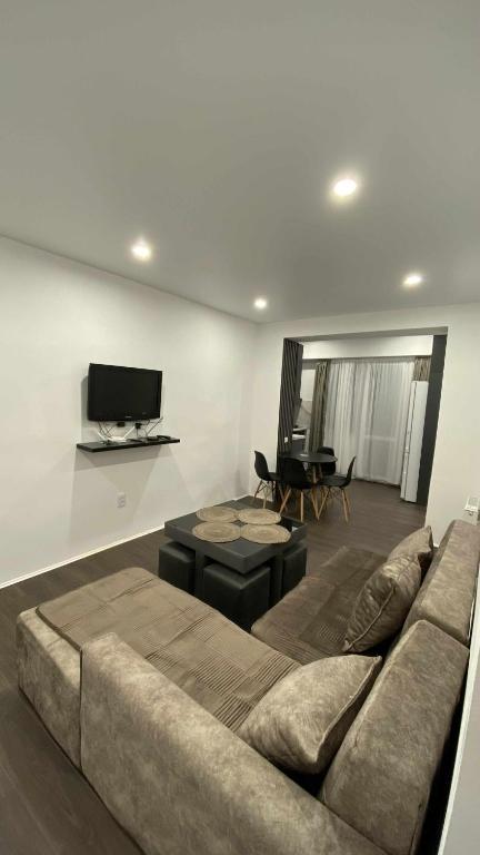 a living room with a couch and a flat screen tv at My Apartment in Kvareli