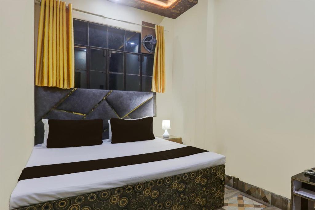 1 dormitorio con 1 cama grande y cortinas amarillas en SPOT ON Welcome Guest House, en Mughal Sarāi
