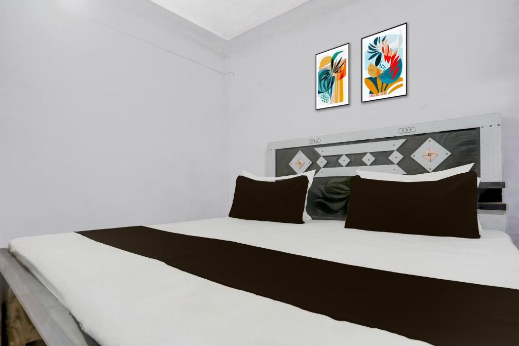 a bedroom with a large white bed with black pillows at SPOT ON Anmay in Phāphāmau
