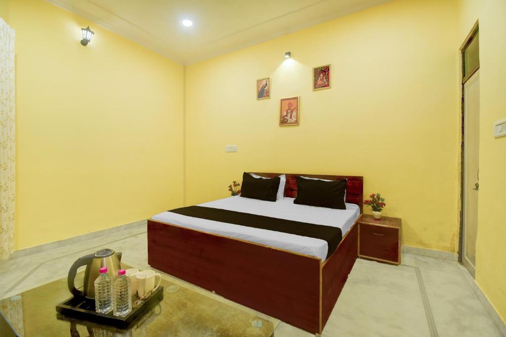 a bedroom with a bed in a room with yellow walls at Hotel O Krishna Palace in Jaipur