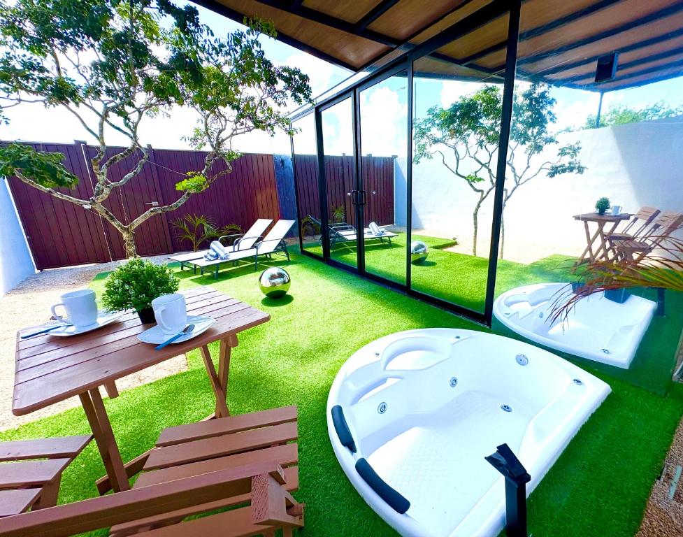 a backyard with a hot tub and a table and bench at TinyHouse OASIS con Jacuzzi&Cenote&Piscina in Telchac Puerto