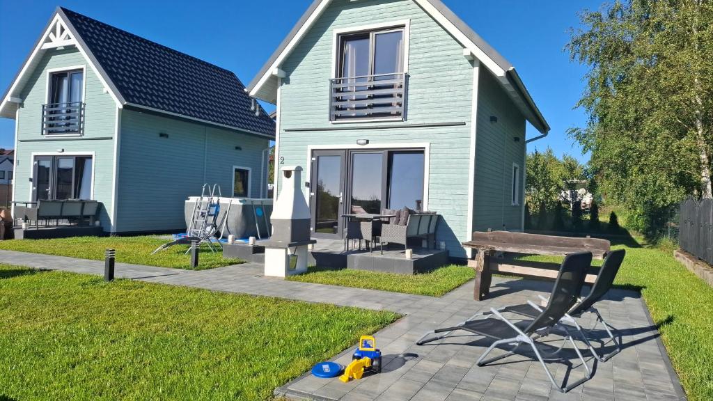 een huis met een tafel en een bank in de tuin bij Domki Morskie Jastrzębia Góra - Domki z basenem in Jastrzębia Góra