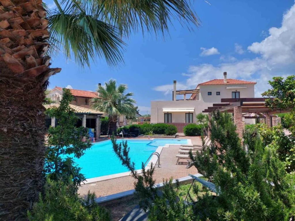 a villa with a swimming pool and a house at Amalthia hotel in Límni