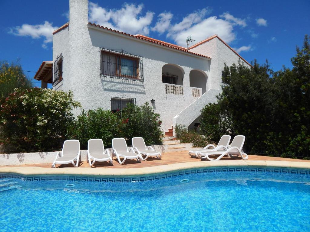a villa with a swimming pool in front of a house at Villa Carfax in Orba