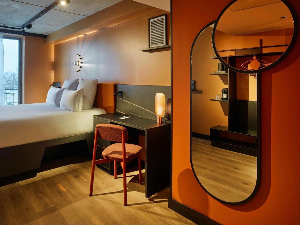 a room with a bed and a desk and a mirror at Tribe Paris Saint Ouen in Saint-Ouen