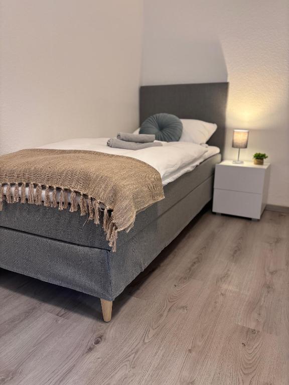 a bedroom with a large bed and a wooden floor at Apartment-Topnik Datteln in Datteln