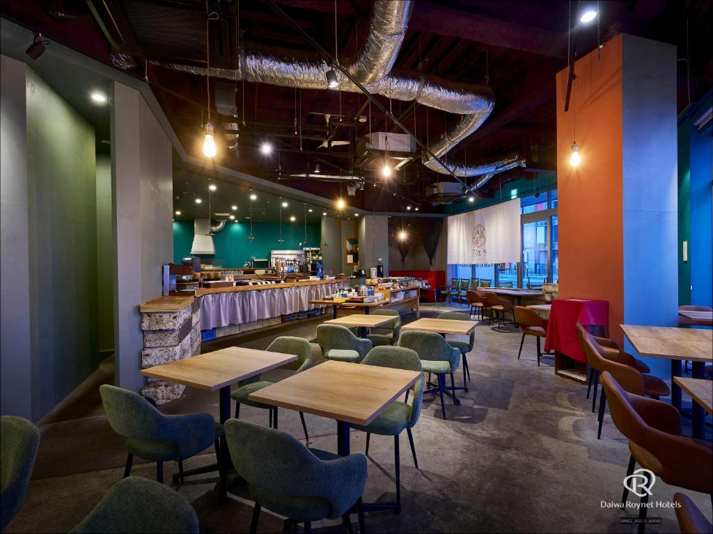 a restaurant with tables and chairs and a bar at Daiwa Roynet Utsunomiya in Utsunomiya