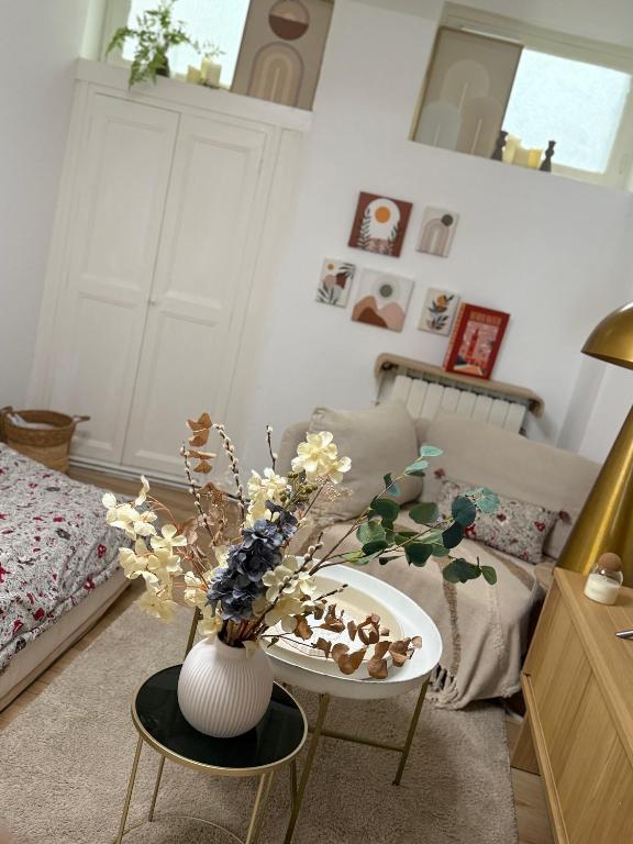 a living room with a vase with flowers on a table at Appartement Cocooning Béziers Cœur historique, charme et confort noté 10 in Béziers