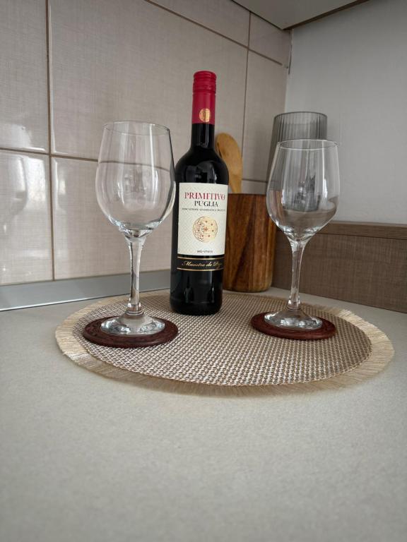 a bottle of wine and two wine glasses on a table at Nova in Bacău