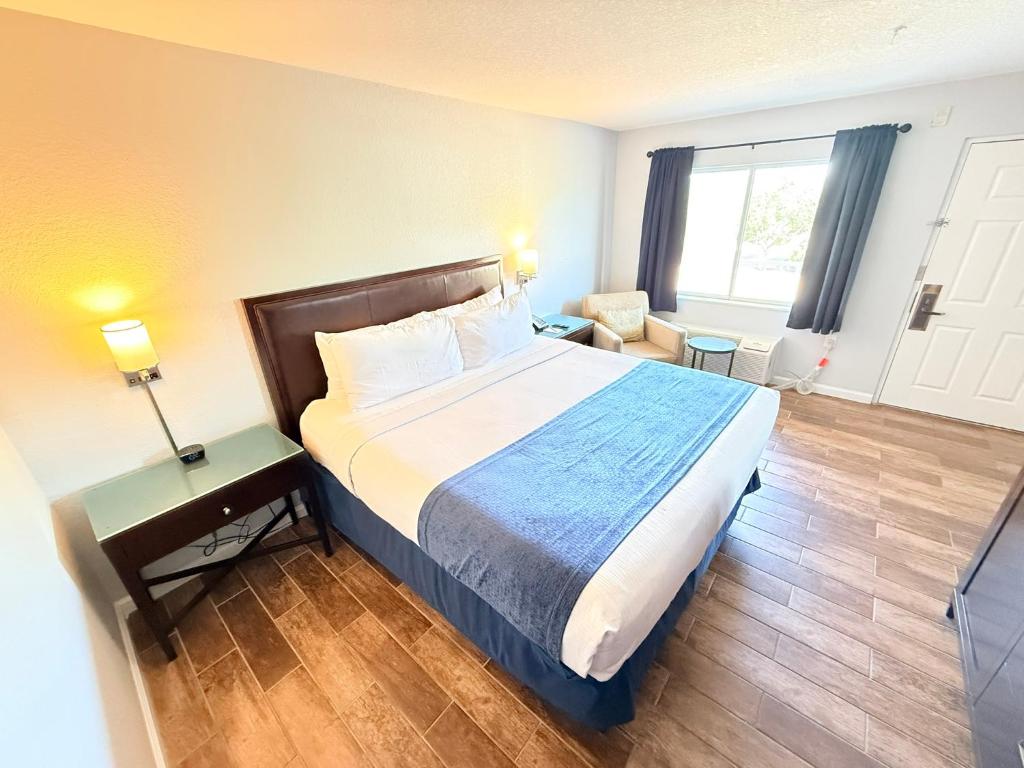 サラソタにあるLantern Inn & Suites - Sarasotaの大きなベッドと椅子のあるホテルの部屋