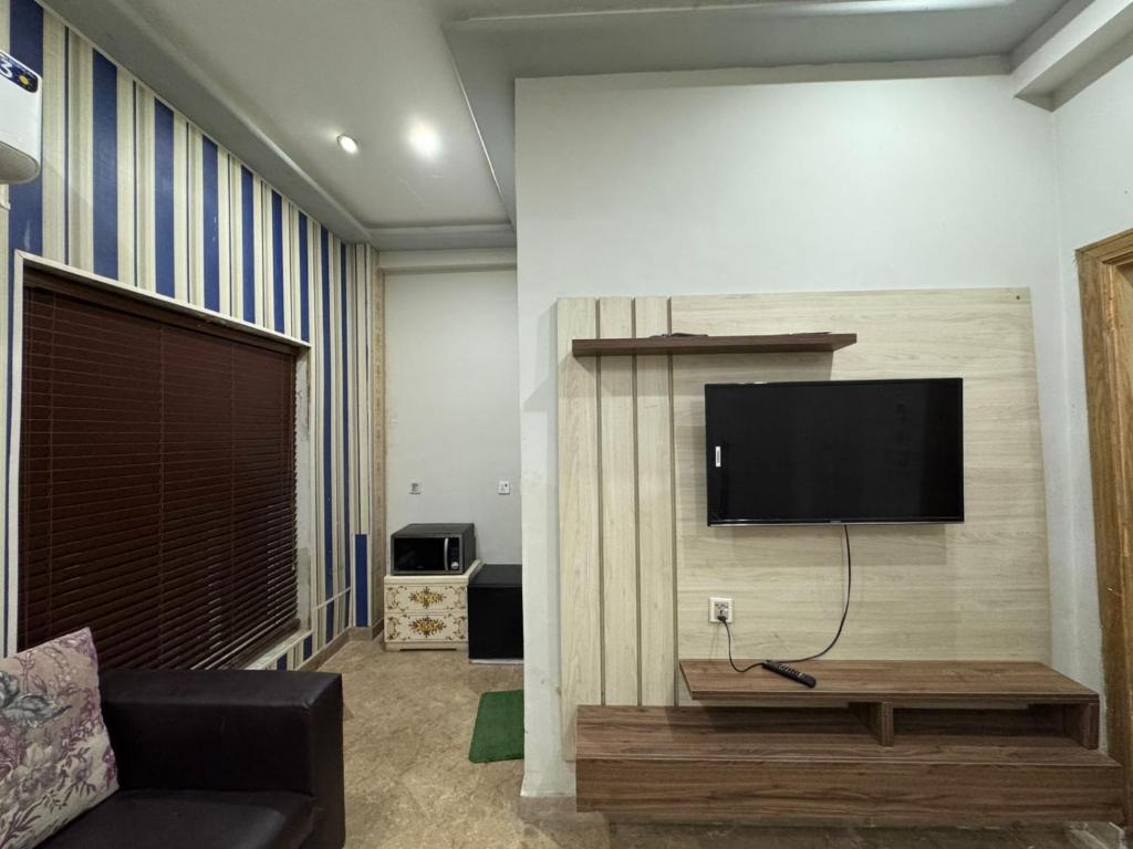 een woonkamer met een flatscreen-tv aan de muur bij 1 bed apartment in Rawalpindi