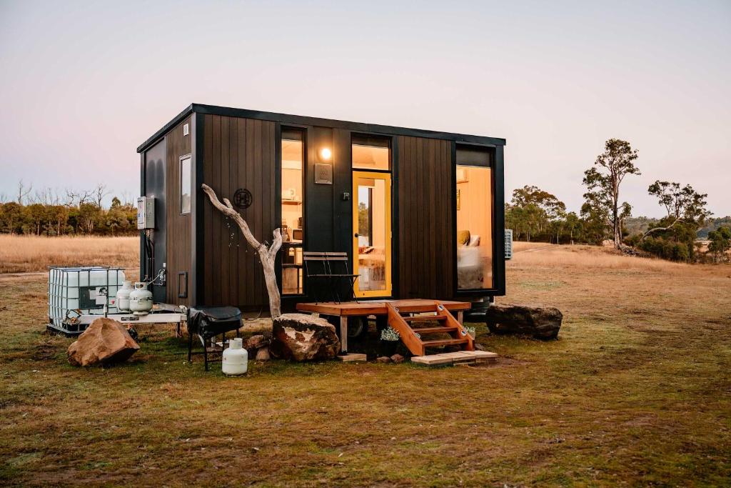 a tiny house in a field with a tree at Hermano Farm Stay by Tiny Away in Greenhills