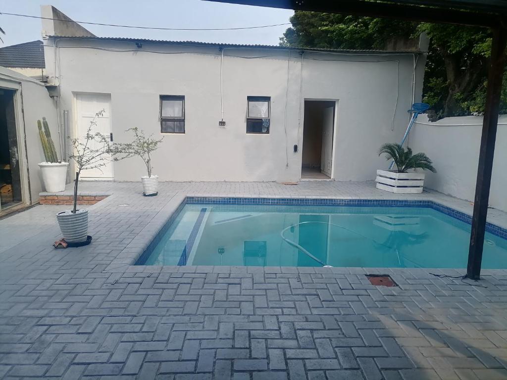 a swimming pool in front of a white building at Hospital View Residence in Boksburg