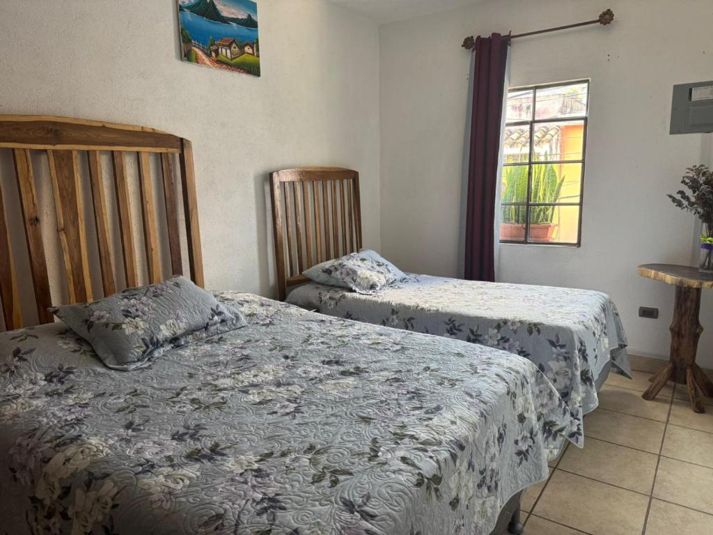 a bedroom with two beds and a window at Habitación en casa familiar in Antigua Guatemala