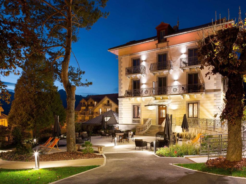 a large white building with a courtyard at night at Le Saint Gervais Hotel & Spa Handwritten Collection in Saint-Gervais-les-Bains