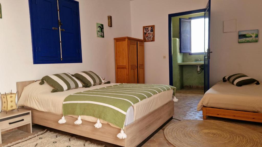 1 dormitorio con 1 cama y armario azul en Dar Anouar, en Sidi Kaouki