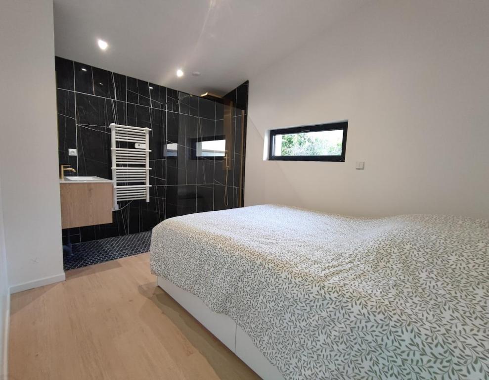 a bedroom with a bed and a bathroom with a sink at A Cozy Loft for You in Conflans-Sainte-Honorine