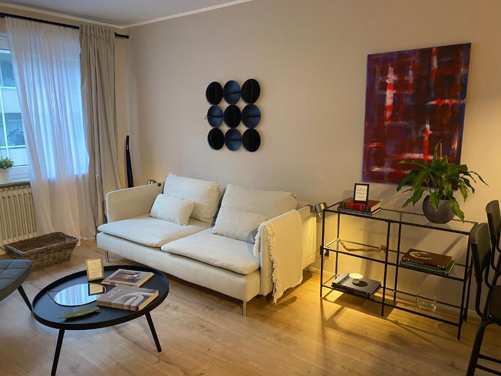 a living room with a white couch and a table at Casa Soden, Artful living just outside the city in Bad Soden am Taunus