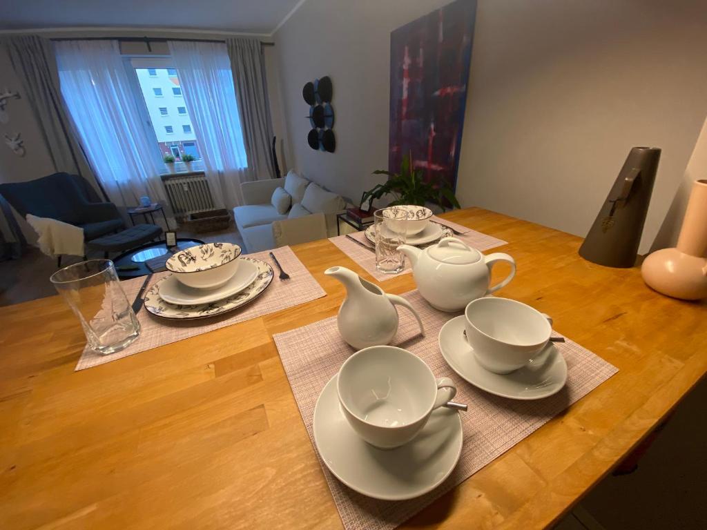 a wooden table with plates and tea sets on it at Casa Soden, Artful living close to Frankfurt in Bad Soden am Taunus