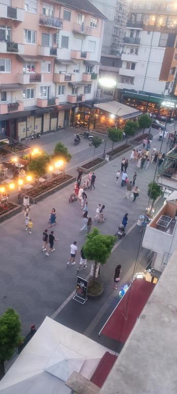 een groep mensen die 's nachts op een binnenplaats zitten bij Gold Apartments in Novi Pazar