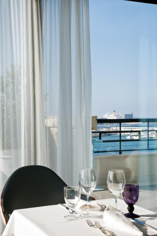 a table with three wine glasses and a window at JR Hotels Bari Grande Albergo delle Nazioni in Bari