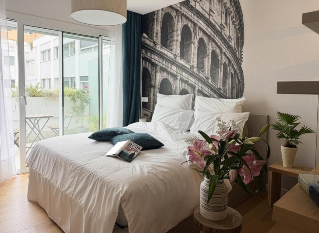 a bedroom with a white bed with a large headboard at Labicum XXII - Modern Luxury Studio near the Colosseum in Rome
