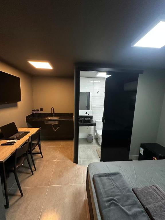 een kamer met een bed en een badkamer met een bad bij Kit aconchegante na W3 Norte in Brasilia