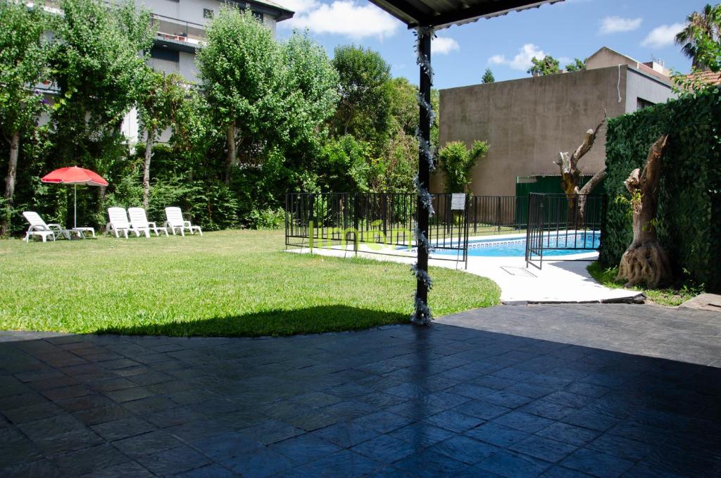 a yard with a fence and a swimming pool at Casa Amplia 5 personas Con Pileta, Amplio Jardin y Parrilla Zona Muy Tranquila en Tigre Centro in Tigre